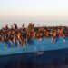 Migrantes se jogam de navio ancorado na Itália